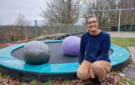 Hanne Christensen sidder på kanten af en trampolin i døgninstitutionen Toppens sansehave.