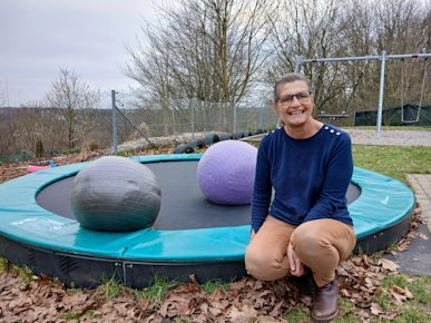 Hanne Christensen sidder på kanten af en trampolin i døgninstitutionen Toppens sansehave.