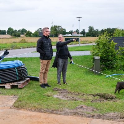 Christina og Thomas Graugaard-Nielsen kigger sammen med hunden Svend på den byggegrund, de købte i 2021på Vesterengen i Viuf