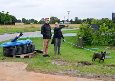 Christina og Thomas Graugaard-Nielsen kigger sammen med hunden Svend på den byggegrund, de købte i 2021på Vesterengen i Viuf