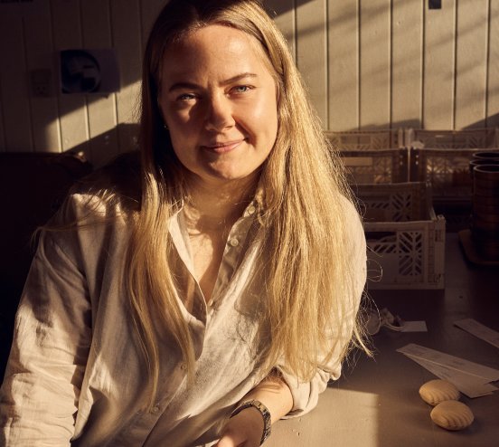 Maria Grønborg sidder ved sit arbejdsbord, hvor der ligger sæbestykker