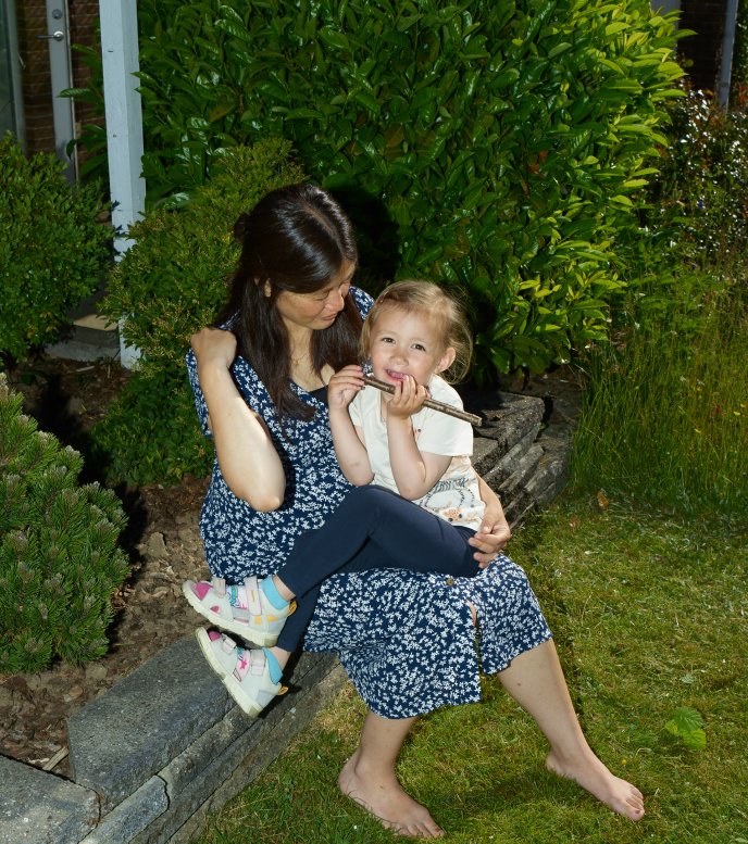 Sanne Kallesøe sidder i haven med sin datter på skødet
