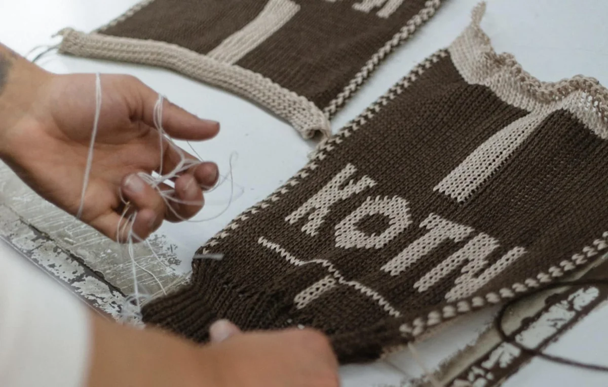 A knitted sample, emblazoned with Kotn.