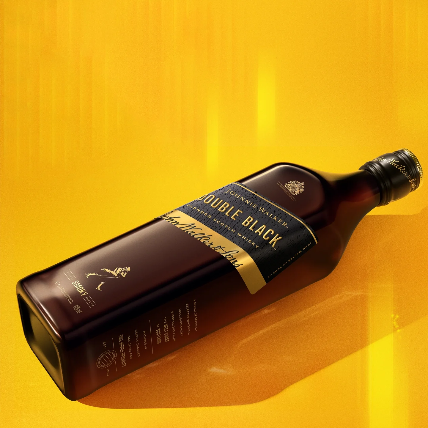 A bottle of Johnnie Walker Double Black whisky lies diagonally on a bright yellow surface, showcasing its dark amber glass and black label with gold lettering.