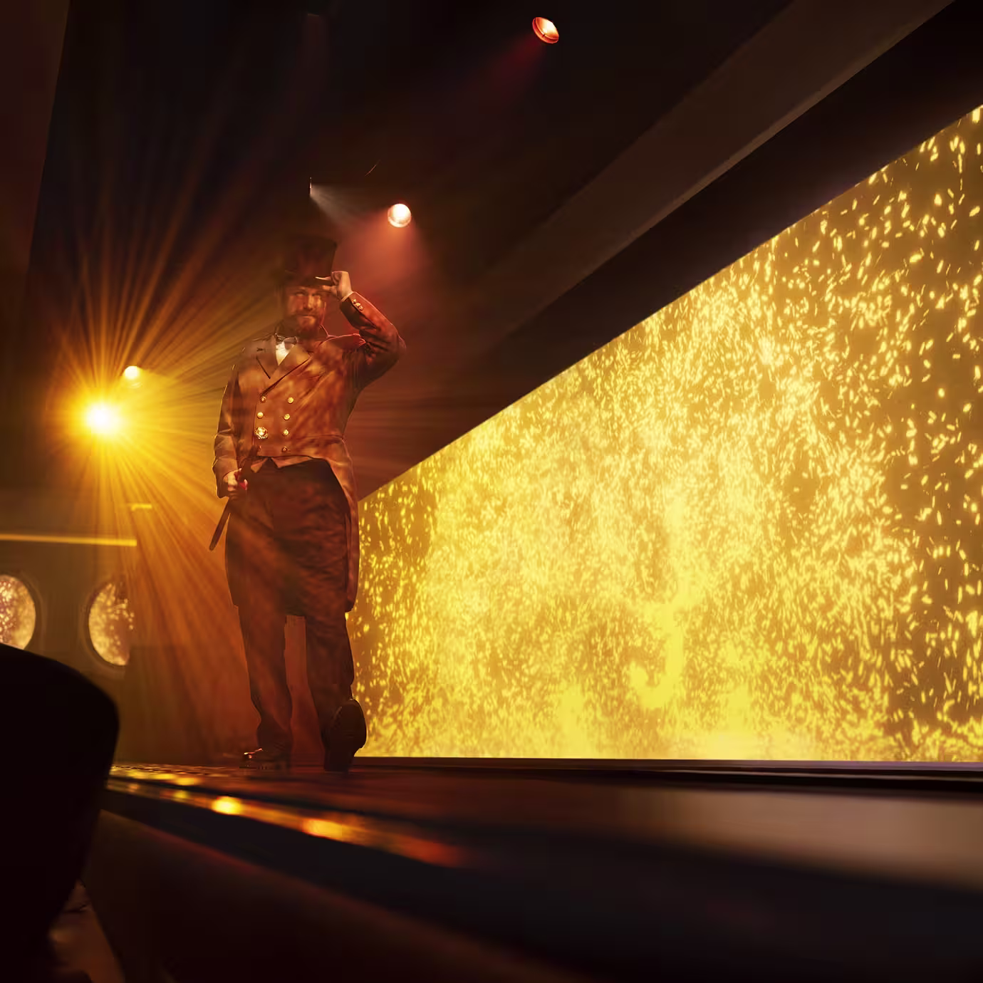 A person in a vintage suit and top hat walks down a runway, tipped hat in hand, with bright golden lights and sparkling effects illuminating the background. The scene has a dramatic, theatrical atmosphere.