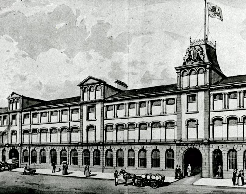 A historic illustration depicting a grand building with ornate details, likely a factory or warehouse from the industrial era.