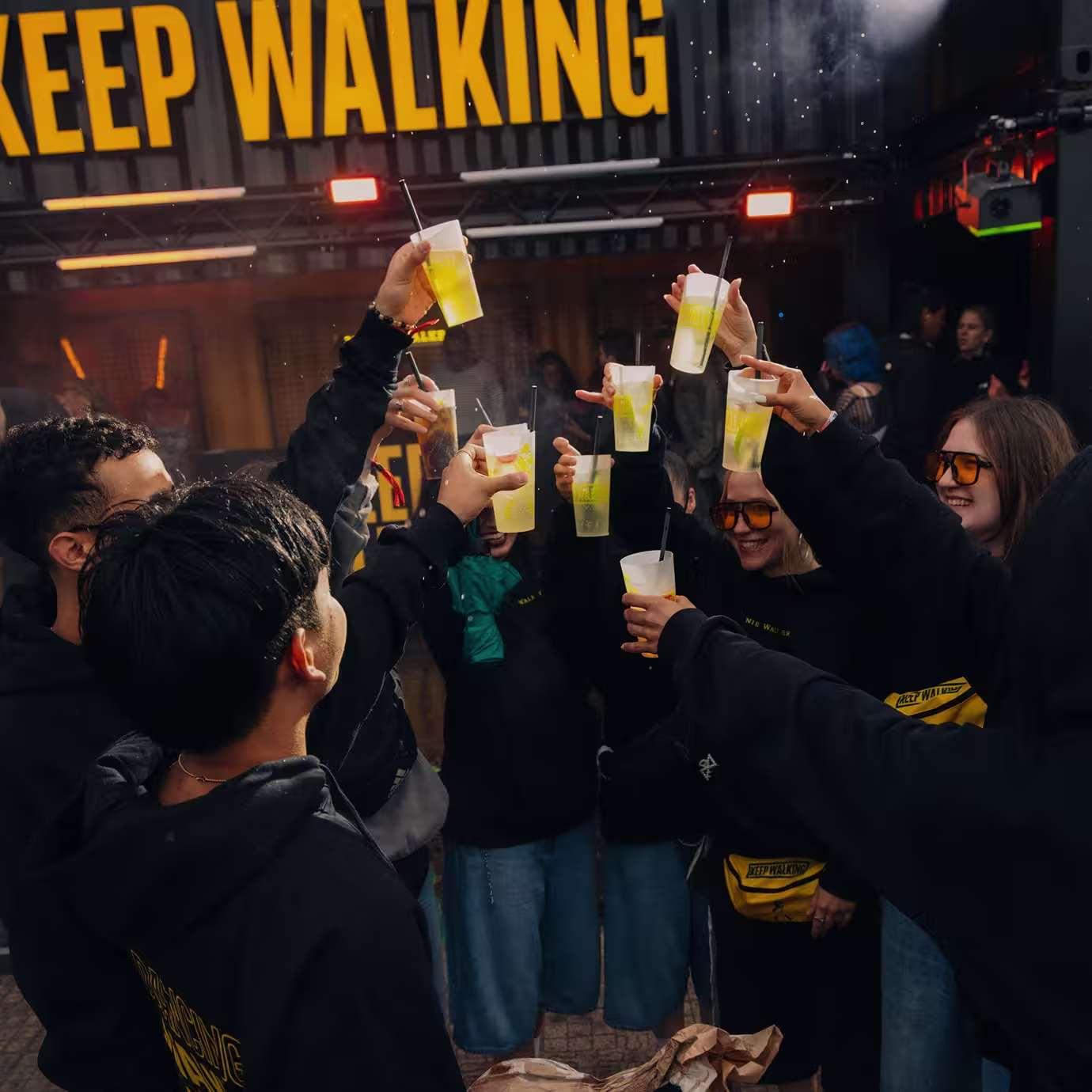 Festivalbesucher an einer Johnnie Walker Bar unter einem großen beleuchteten Keep-Walking-Schriftzug.