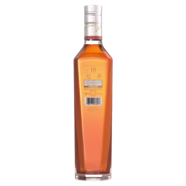 A tall, angular glass bottle filled with amber-colored liquid, shown from the back. The bottle has a silver cap and a barcode label with text near the top. The liquid inside appears to be a type of alcohol.