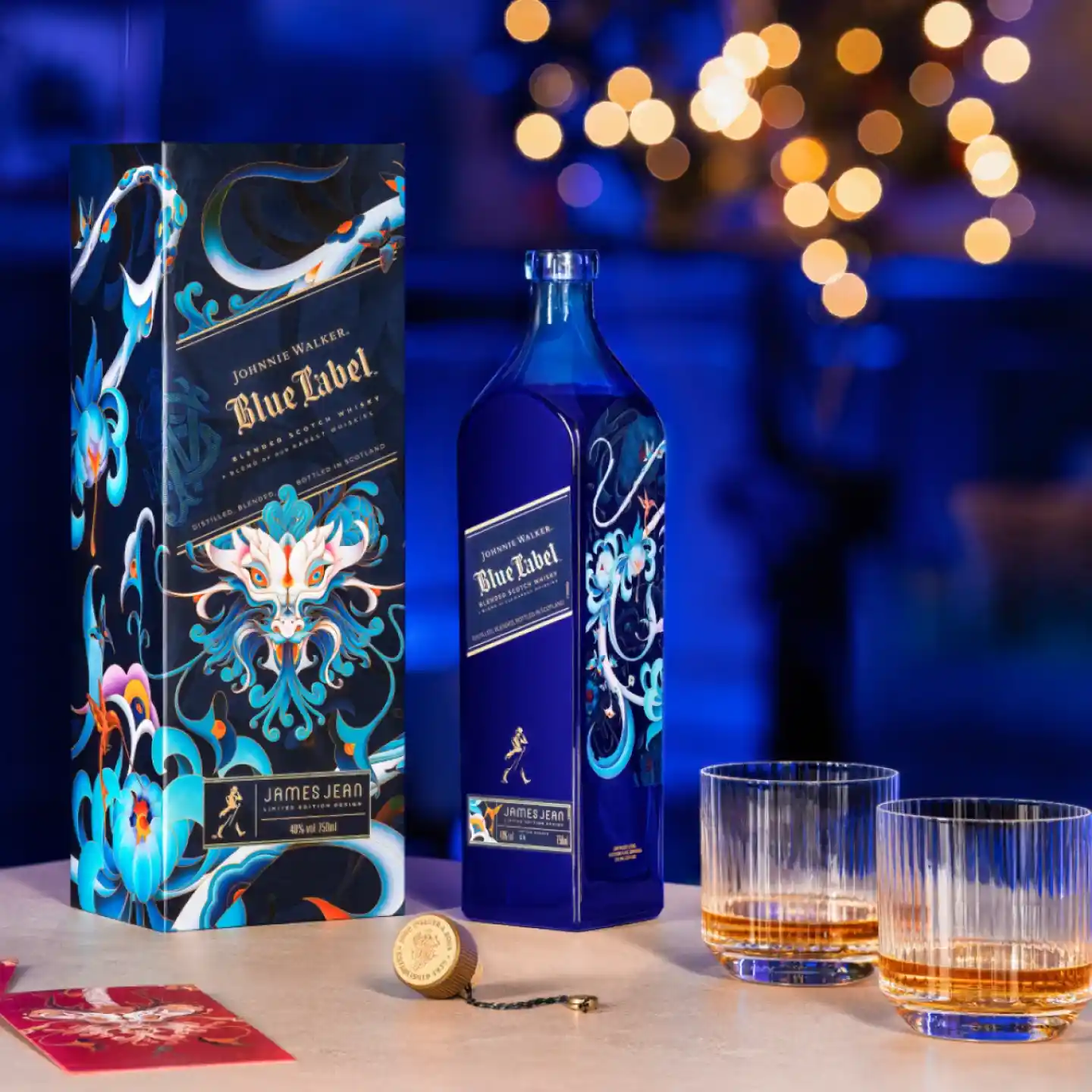 Eine Flasche Johnnie Walker Blue Label in einer dekorativen Schachtel auf einem Tisch, daneben zwei Gläser mit bernsteinfarbener Flüssigkeit. Der Hintergrund ist sanft mit Bokeh-Lichtern beleuchtet.