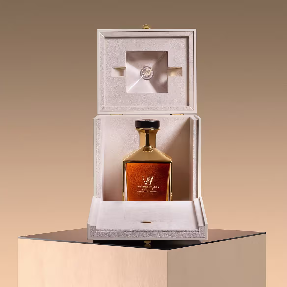 A luxurious bottle of Johnnie Walker whiskey displayed upright in an open, elegant cream-colored box with a soft interior, placed on a reflective, black pedestal against a warm beige background.
