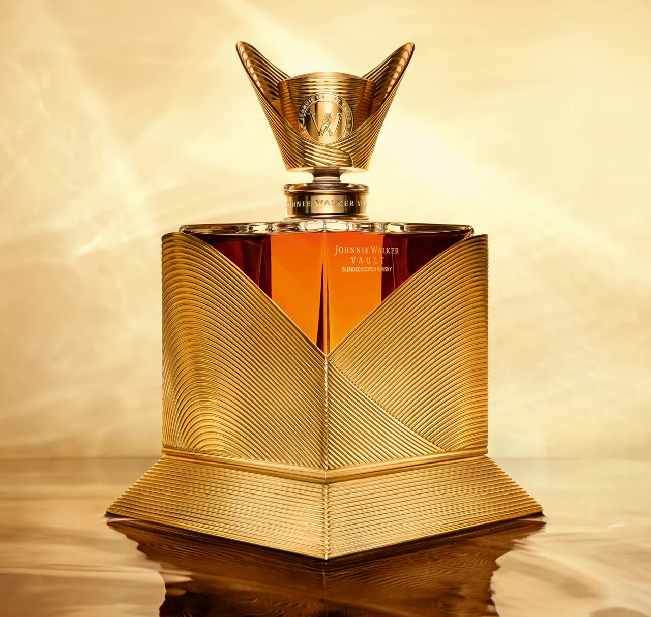 A luxurious golden bottle of Johnnie Walker whisky with intricate, textured designs and a sculpted cap, set against a golden background with reflective surfaces.