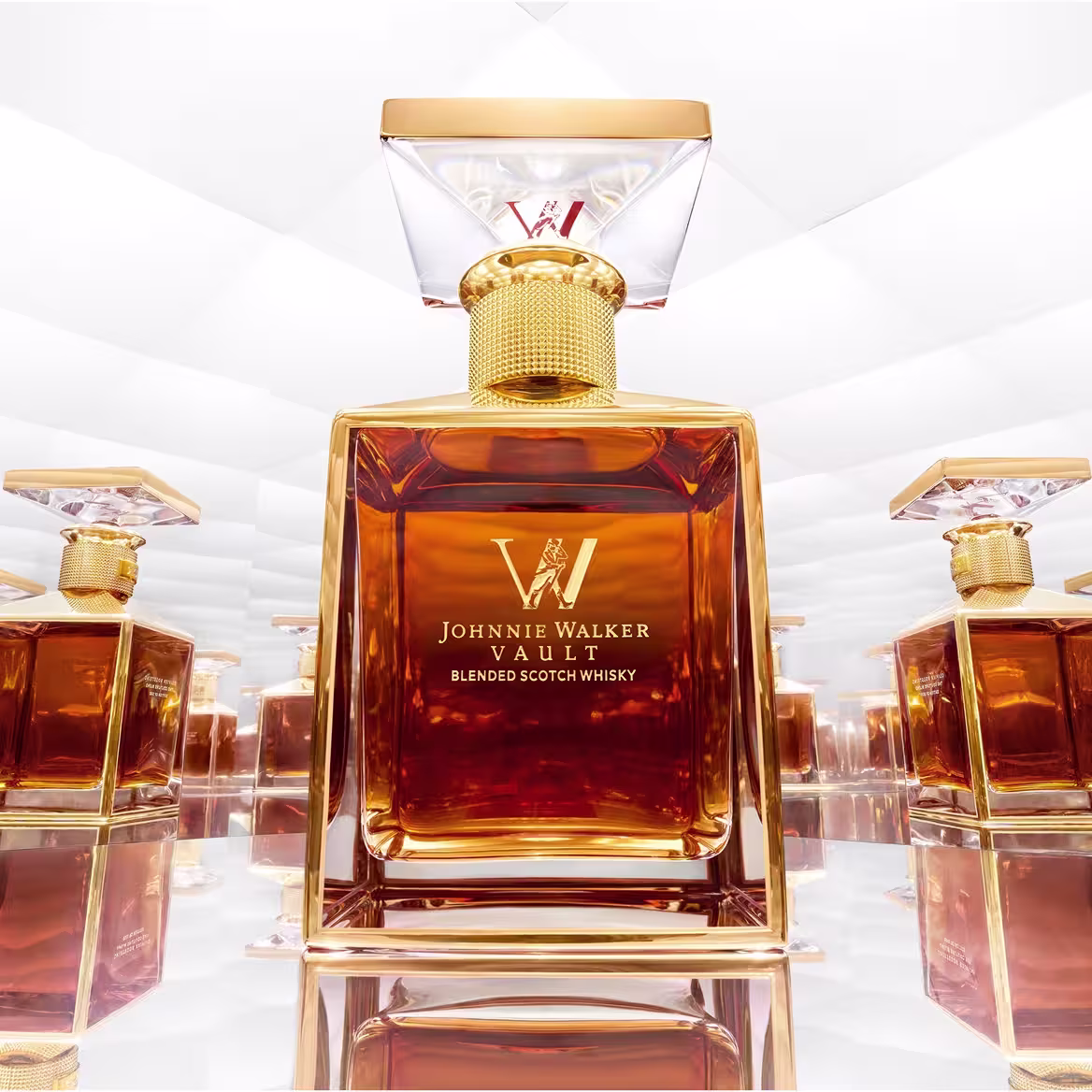 A luxurious Johnnie Walker Vault blended scotch whisky bottle with a faceted glass stopper, reflected multiple times in a mirrored, white-lit environment.