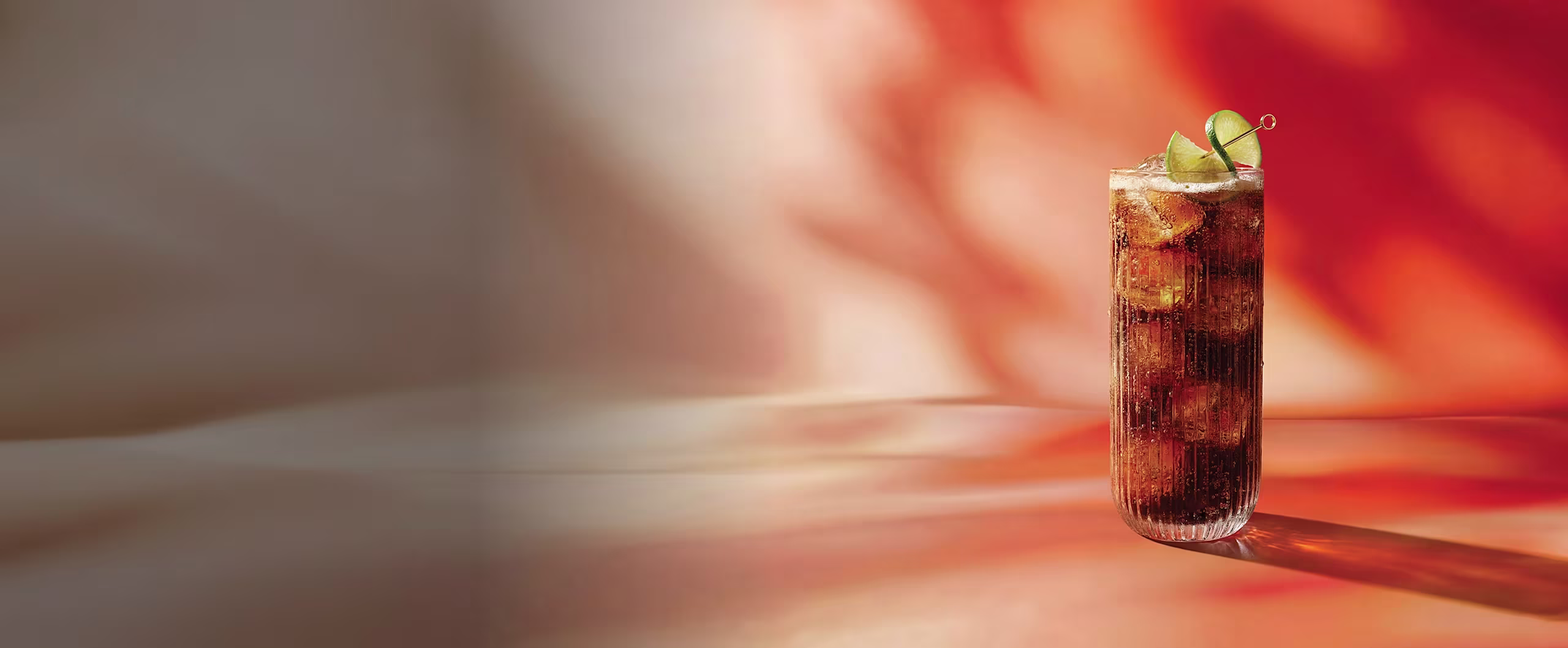 A bottle of Johnnie Walker Red Soul blended Scotch whisky on a red and orange abstract background.