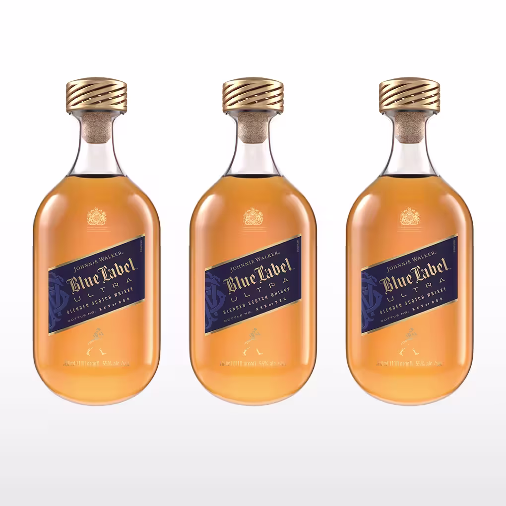 Tres botellas de whisky Johnnie Walker Blue Label con tapas doradas y etiquetas azules se muestran una al lado de la otra sobre un fondo degradado claro.