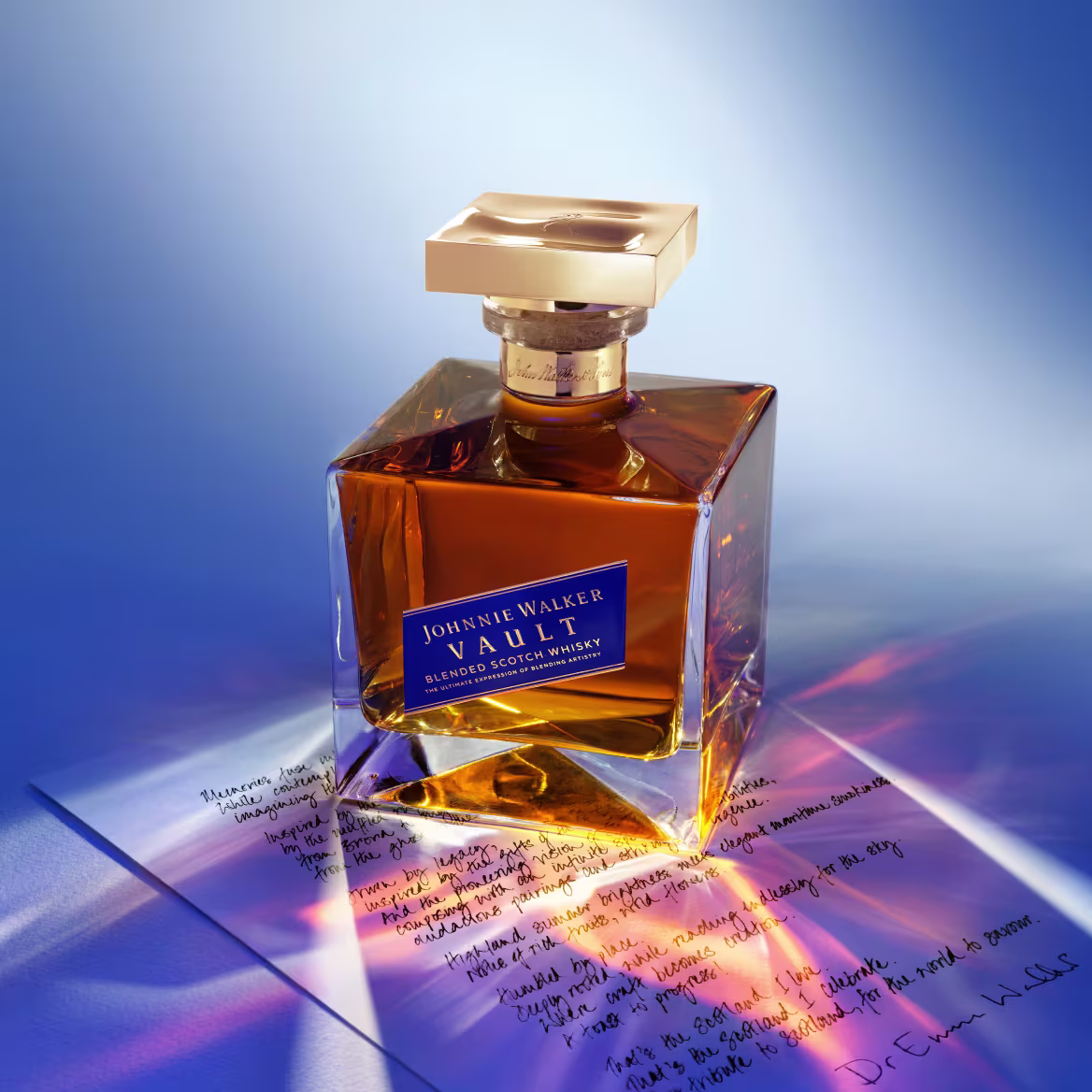 A bottle of Johnnie Walker Vault resting on a handwritten letter in soft blue and amber light.