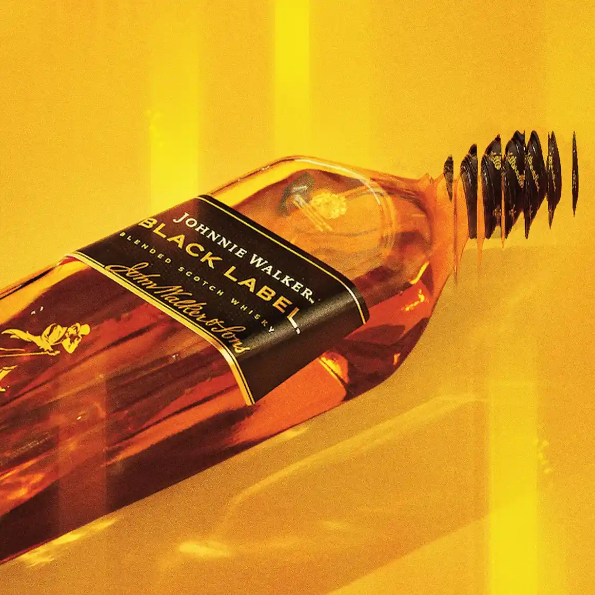 Láhev skotské whisky Johnnie Walker Black Label je nakloněna na bok proti zářivě žlutému pozadí s odstraněným uzávěrem a nad ním se objevuje několik uzávěrů, které ilustrují pohyb.