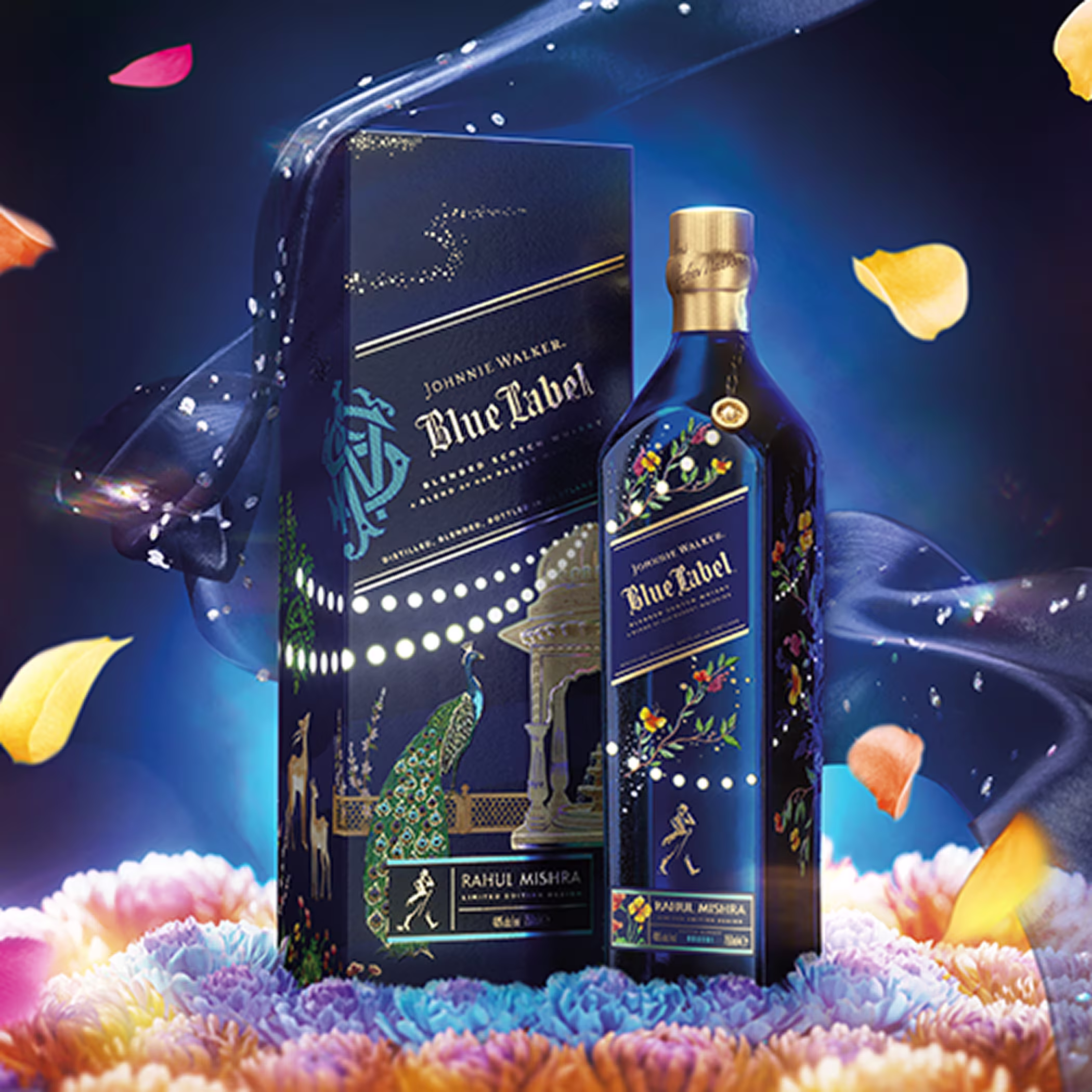 Johnnie Walker Blue Label x Rahul Mishra 2025 limited edition bottle and box on a bed of colourful flowers under a night sky with floating petals.