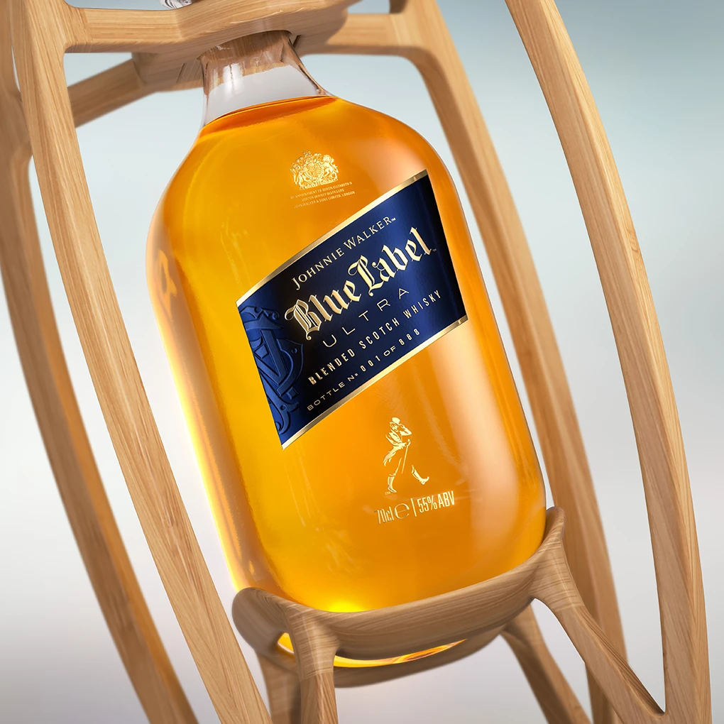 A close-up of a bottle of Johnnie Walker Blue Label Ultra blended Scotch whisky, featuring a blue and gold label, displayed in a modern wooden holder. The whisky has a rich amber color.