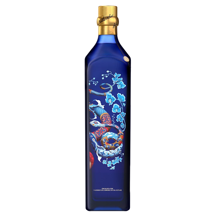 Una botella alta Blue Label Limited Edition Year of the Snake, con tapón dorado, presenta intrincados diseños de flores azules y una colorida serpiente. La botella es elegante, con una mezcla de motivos abstractos y florales en colores vibrantes.