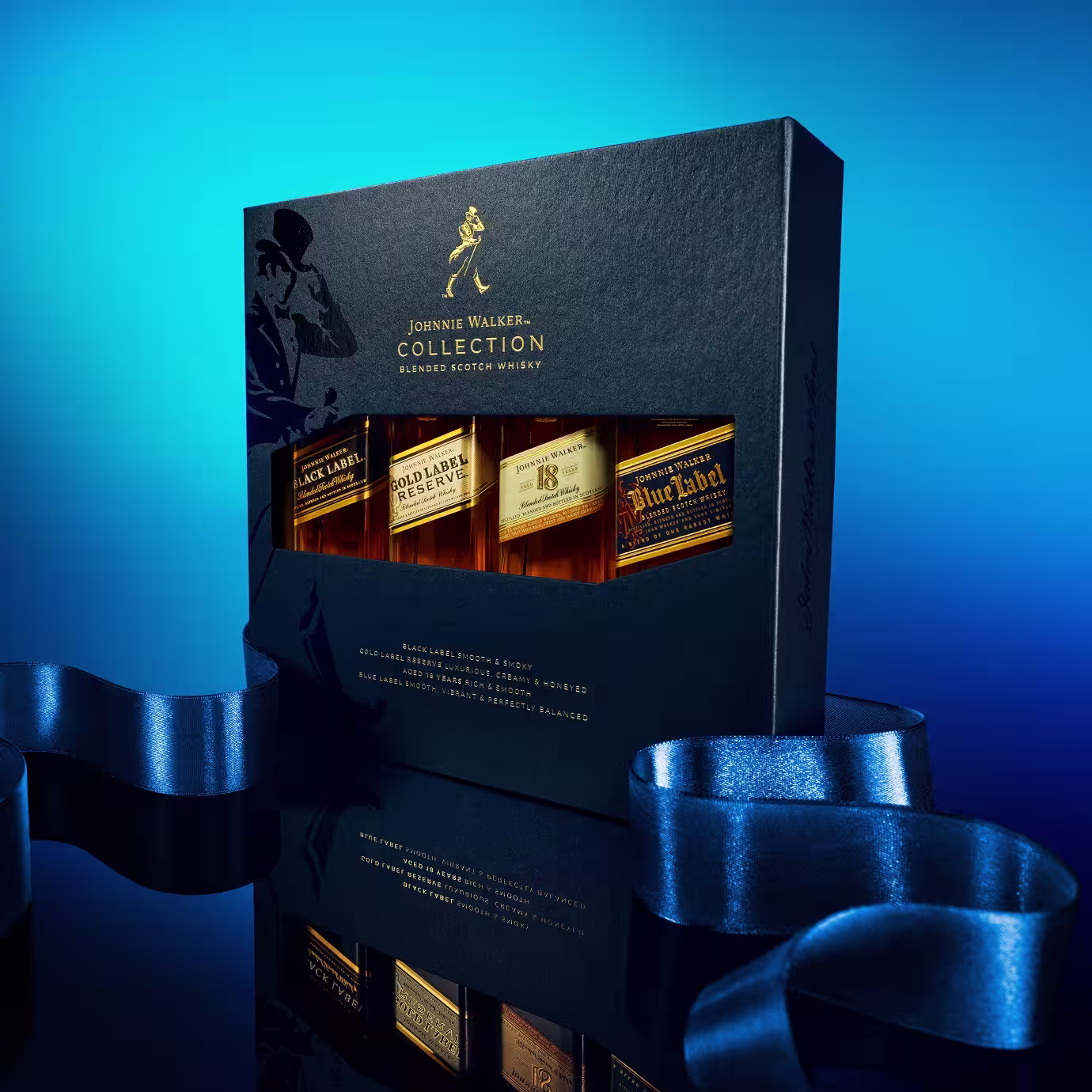 A Johnnie Walker Collection gift set featuring three whisky bottles in a sleek dark box, displayed on a glossy surface with a blue ribbon and illuminated by a blue gradient background.