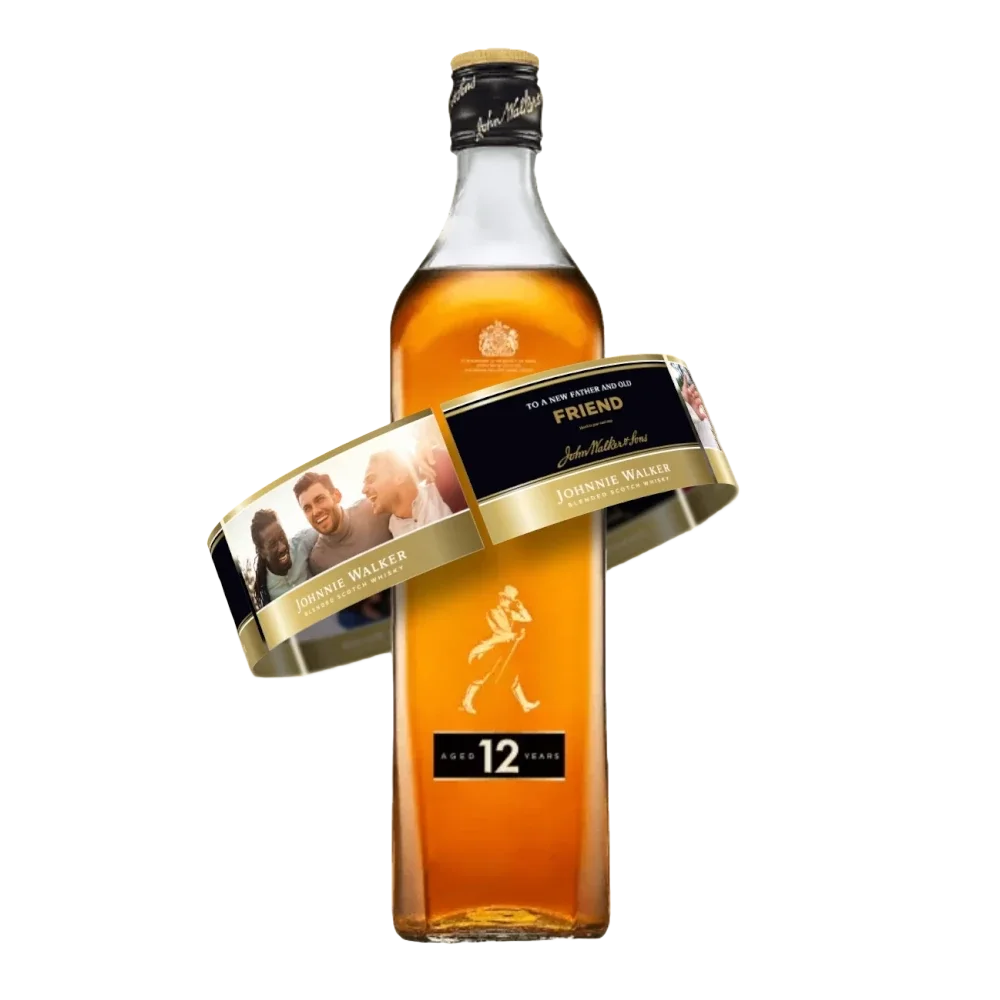 Une bouteille de whisky Johnnie Walker Black Label avec une étiquette personnalisée enroulée autour, comportant des photos de trois personnes souriantes et le mot AMI au-dessus de la marque standard.