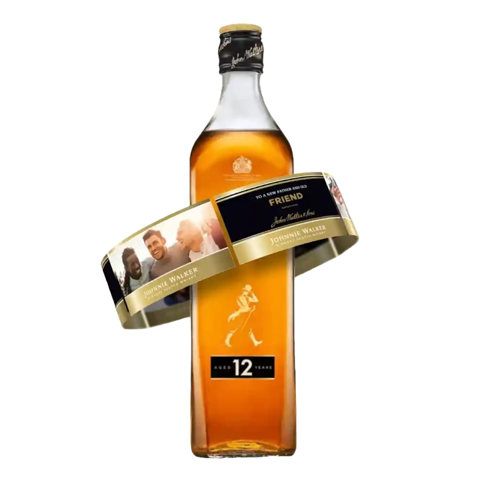 A bottle of Johnnie Walker Black Label whisky with a personalized label wrapped around it, featuring a photo of three people and the word Friend. 