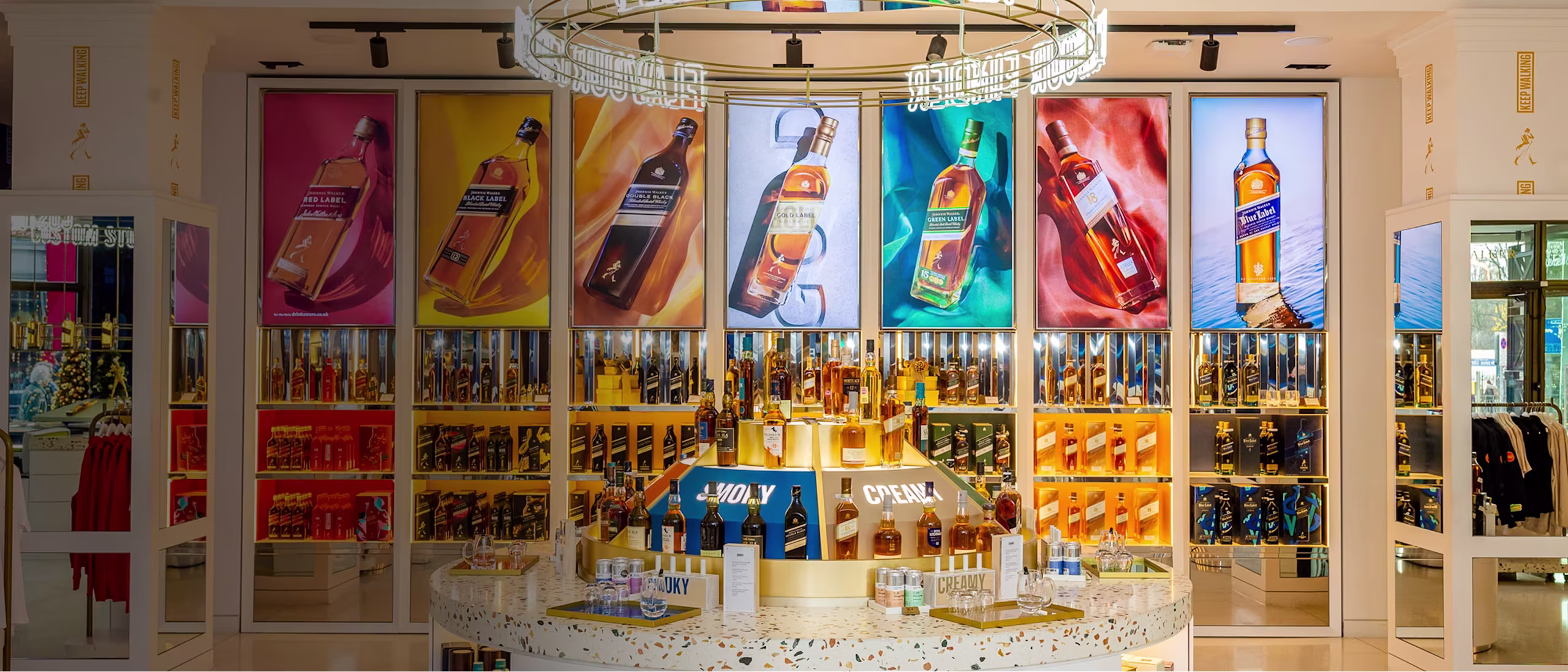 A liquor store display features various bottles and colorful posters of whisky bottles on the back wall.