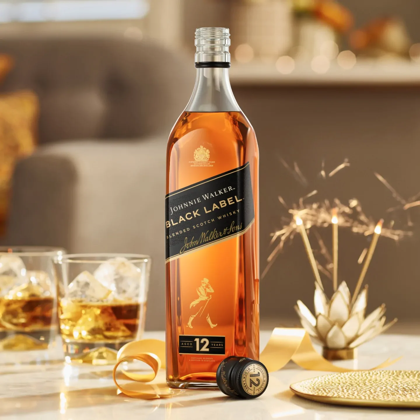 Пляшка віскі Johnnie Walker Black Label на столі з двома склянками віскі та льодом. Підстаканник і стрічка розташовані поруч, а на фоні розмитий фон — спалах і кімната, що створює святкову атмосферу.