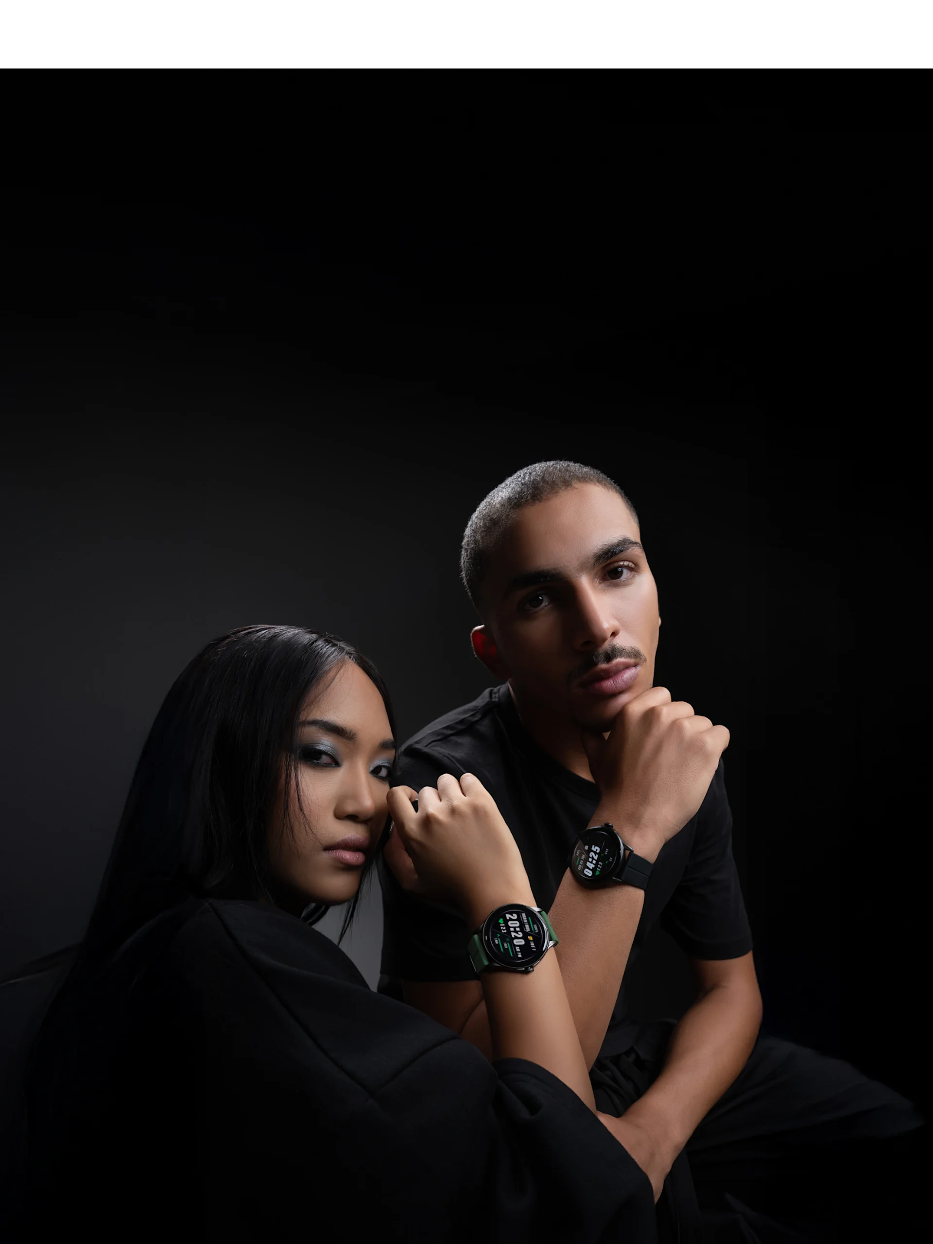 Two people in black outfits pose with HMD Watch X1 on their wrists against a dark background.
