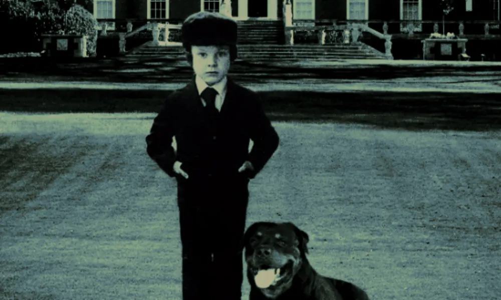 young boy standing with rottweiler