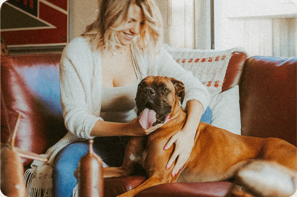 woman sits with dog on couch