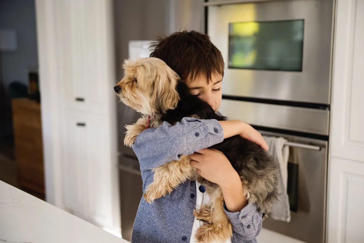 child hugging dog