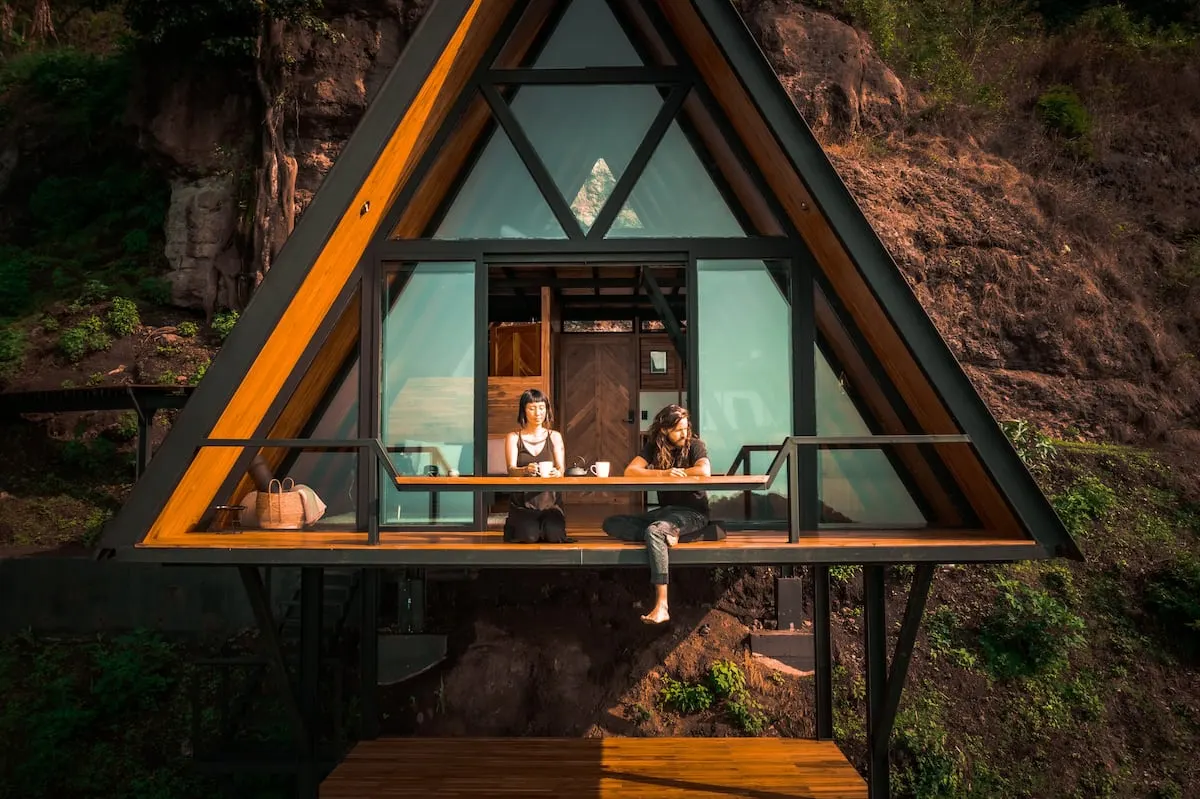 couple sits on balcony of a-frame home in Guatemala