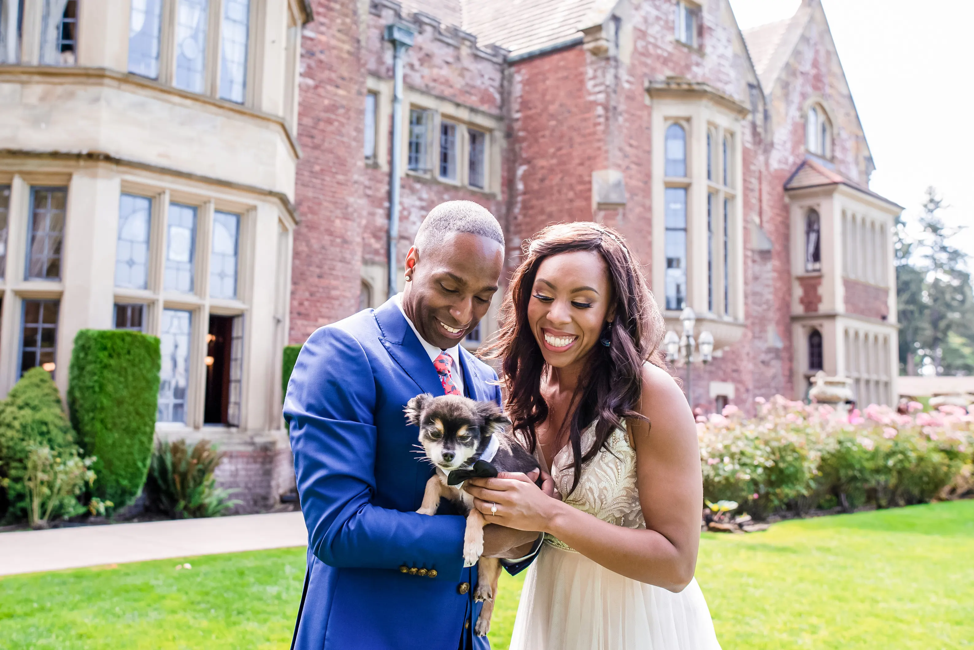 couple smiling for wedding photos with dog in hand