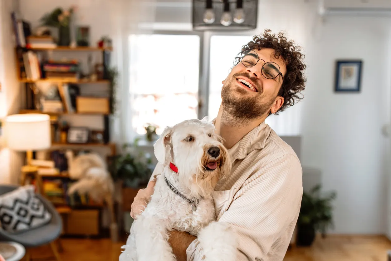 young man smiling and holding dog