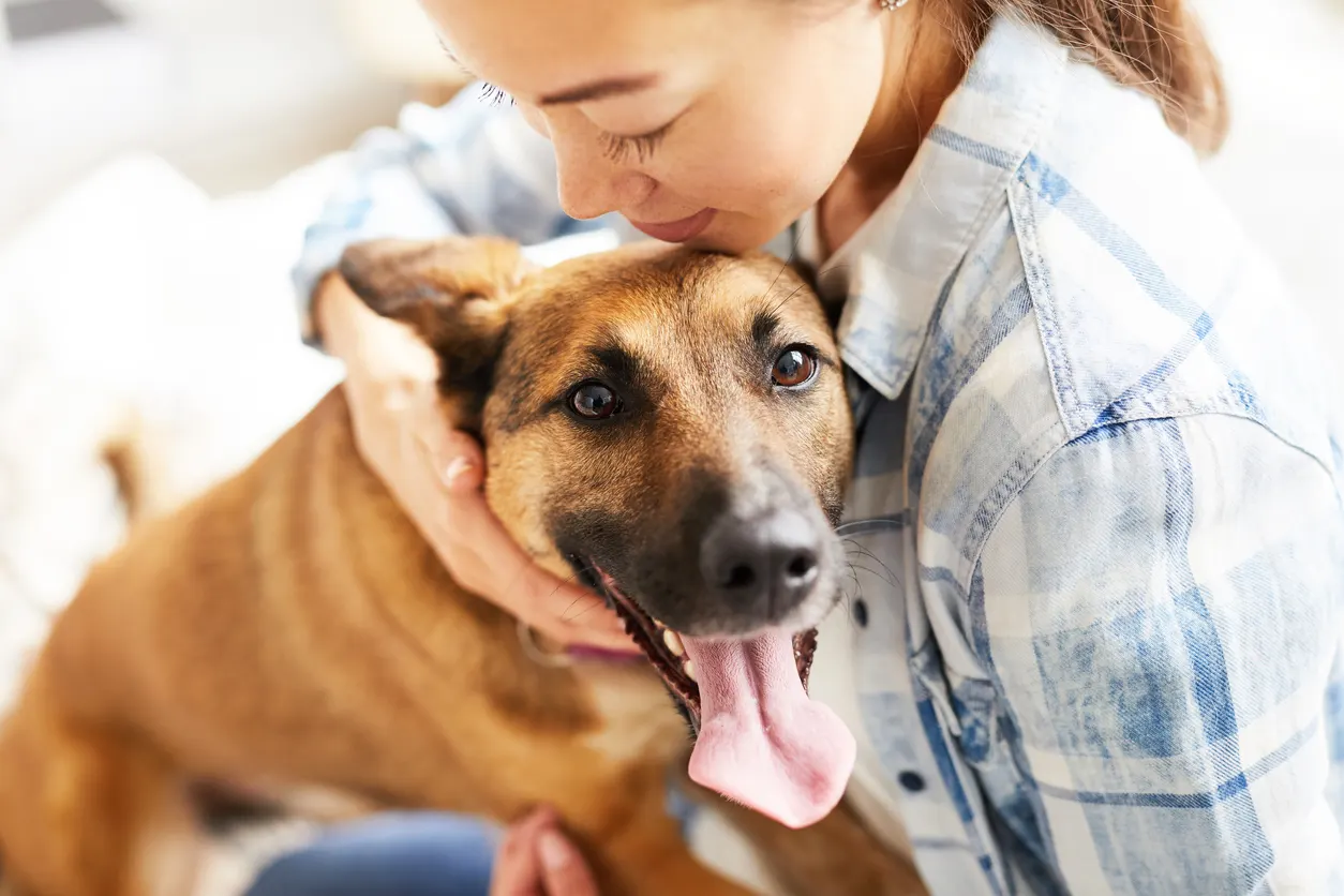 woman hugging dog tight to her chest