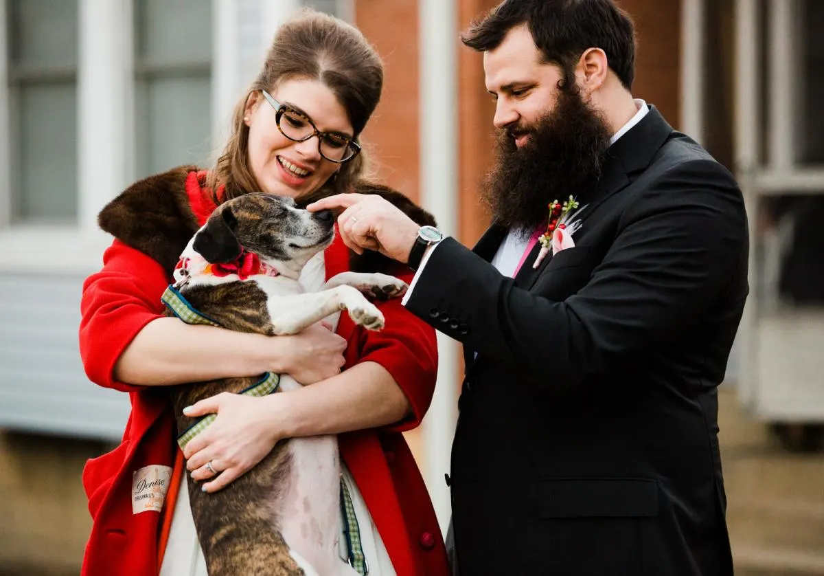 married couple poses with their dog