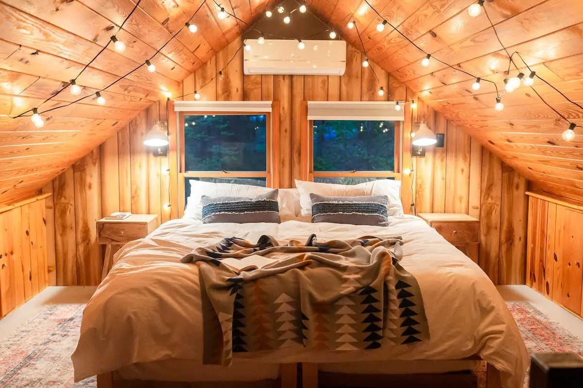 cozy mountain airbnb bedroom with string lights