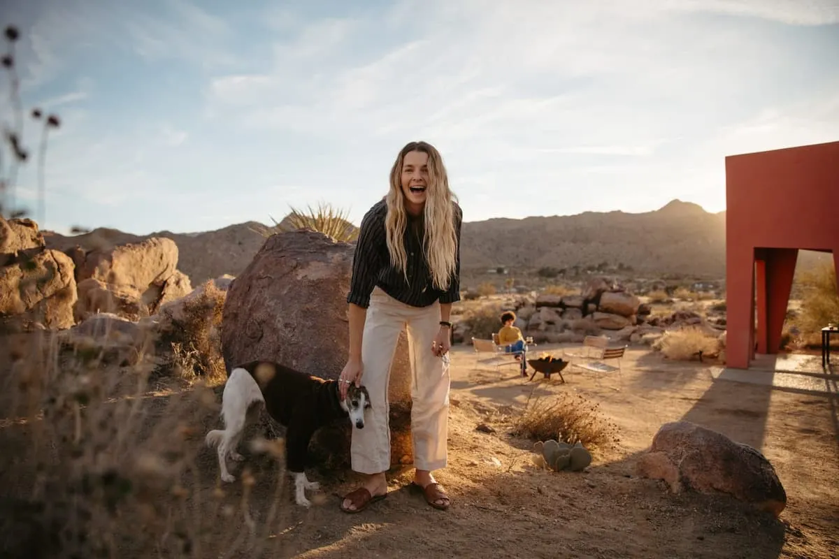 woman poses with dog in front of amazing airbnb
