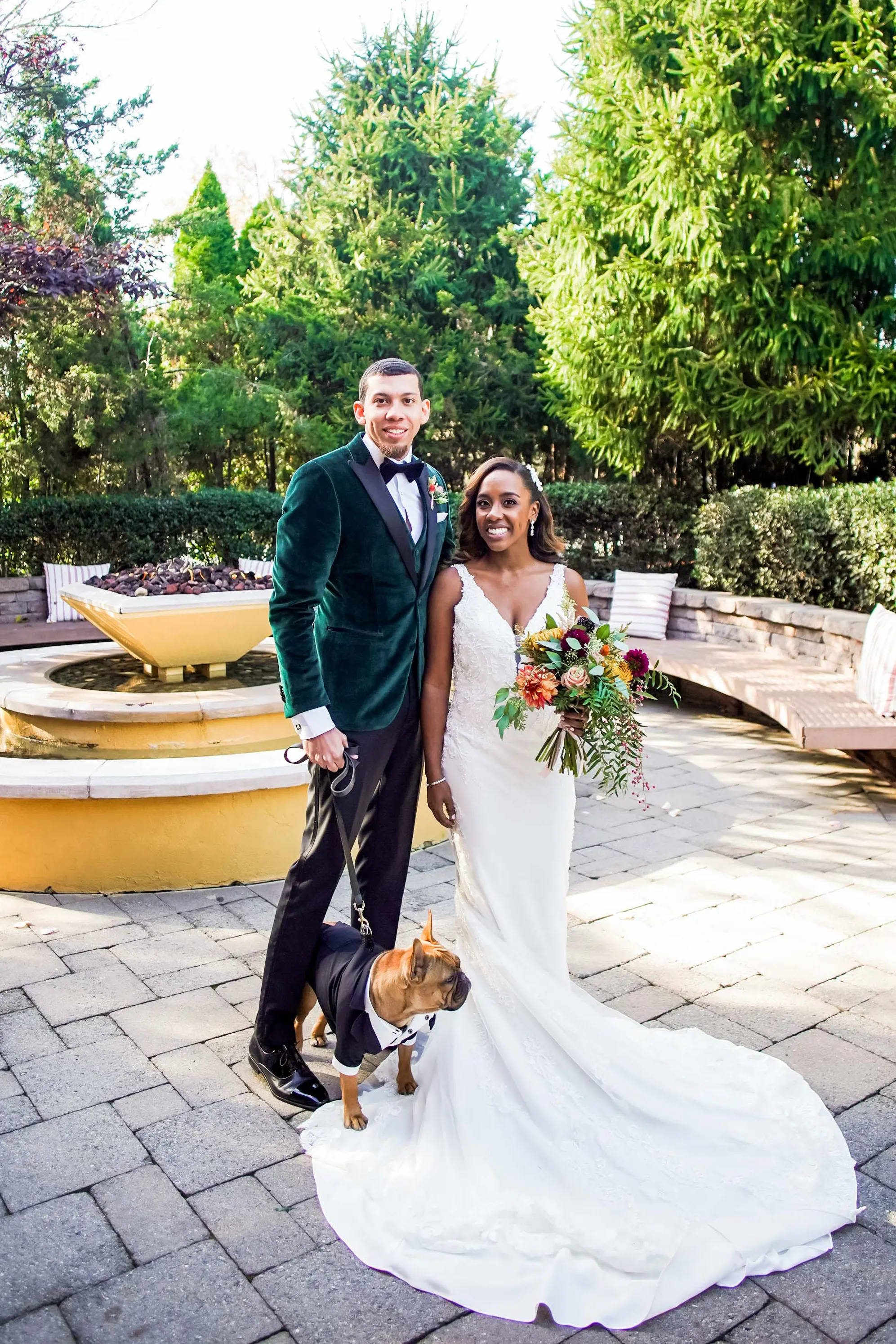 couple on wedding day posing with dog