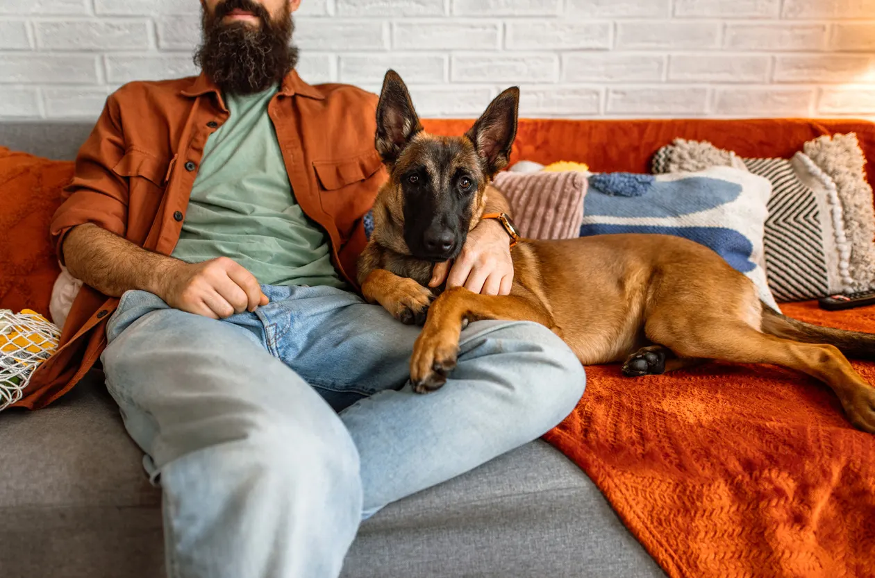 Man sits with dog on couch