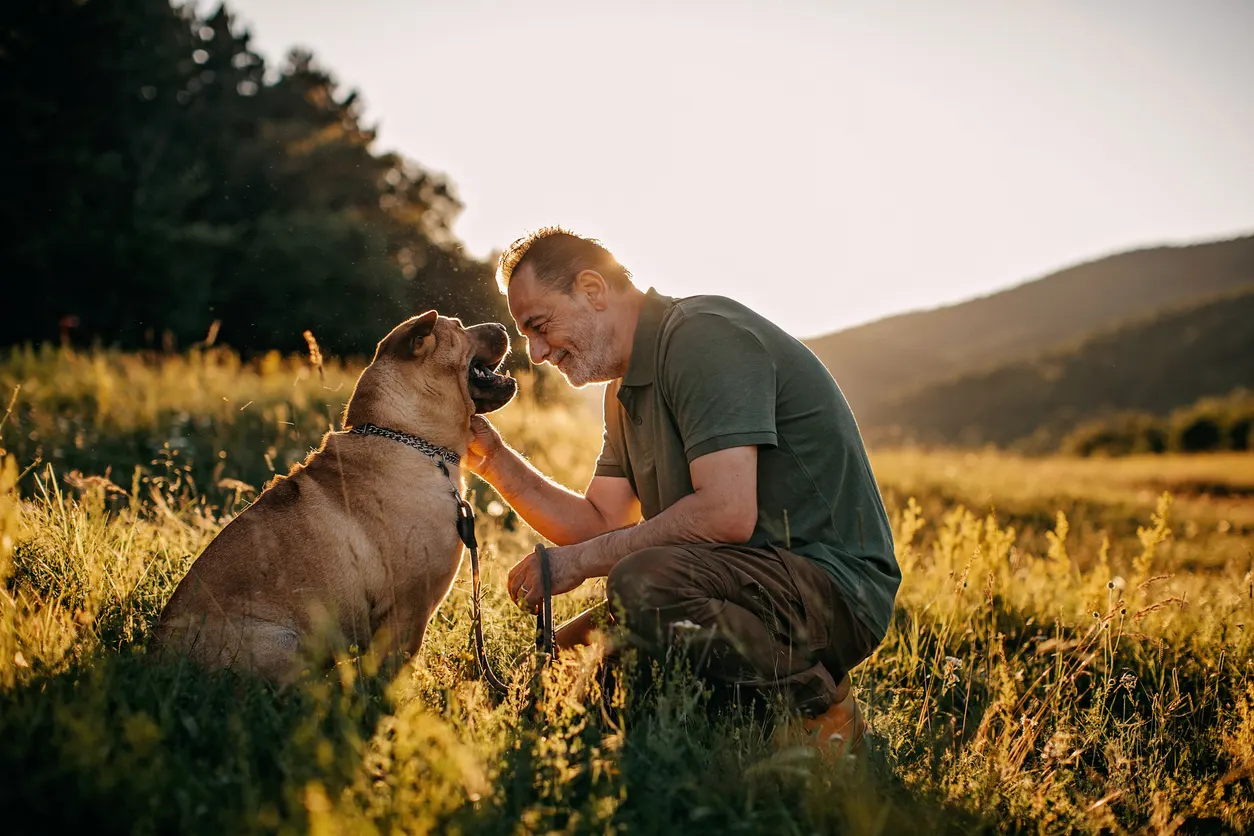 Older man sharing moment with dog outside