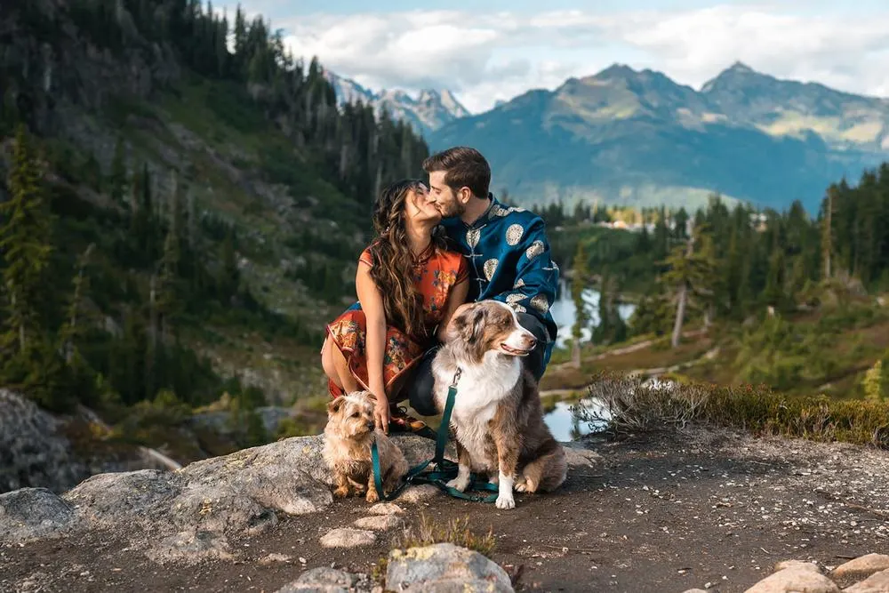 Couple on hike after wedding posing with dog