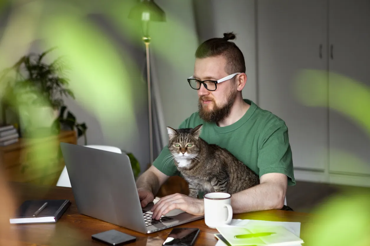 man and cat sitting while working