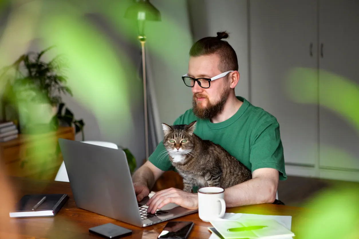 man and cat sitting while working