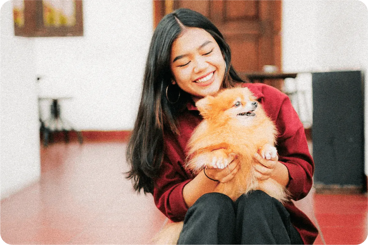 Woman sitting with Pomeranian in lap