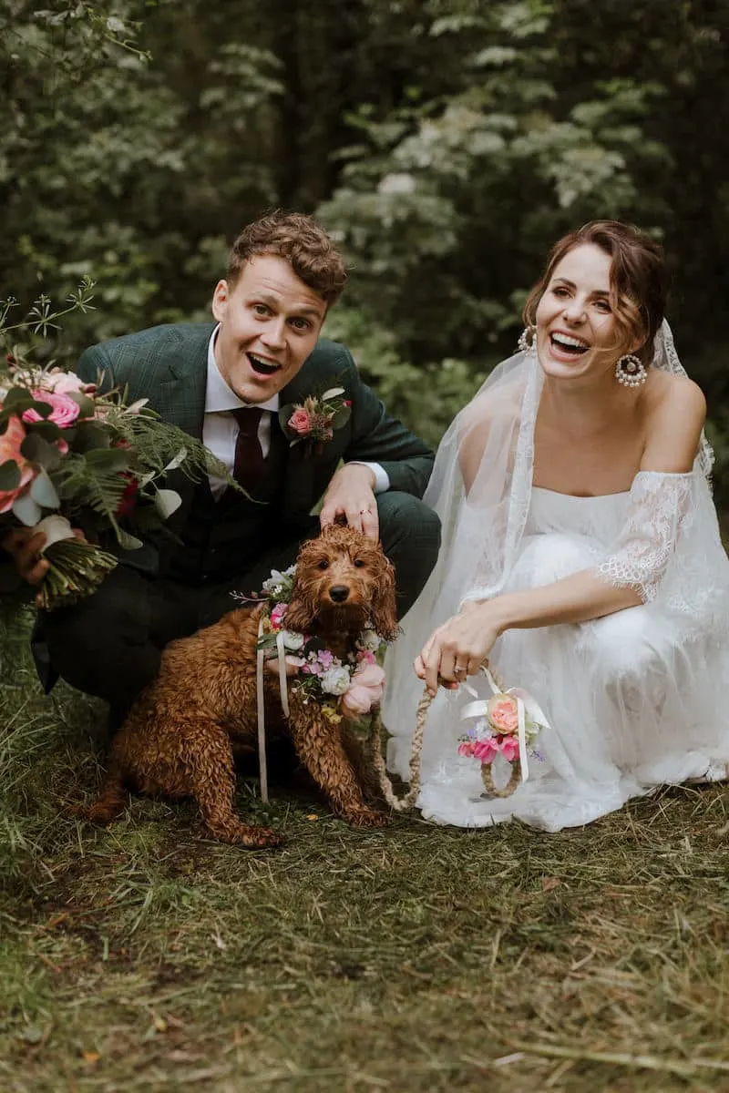 husband and wife at wedding posing with their dog