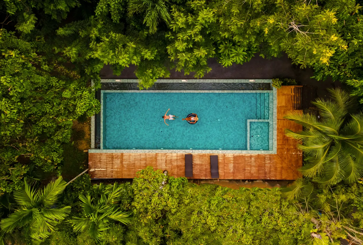 couple swimming in pool in the jungle
