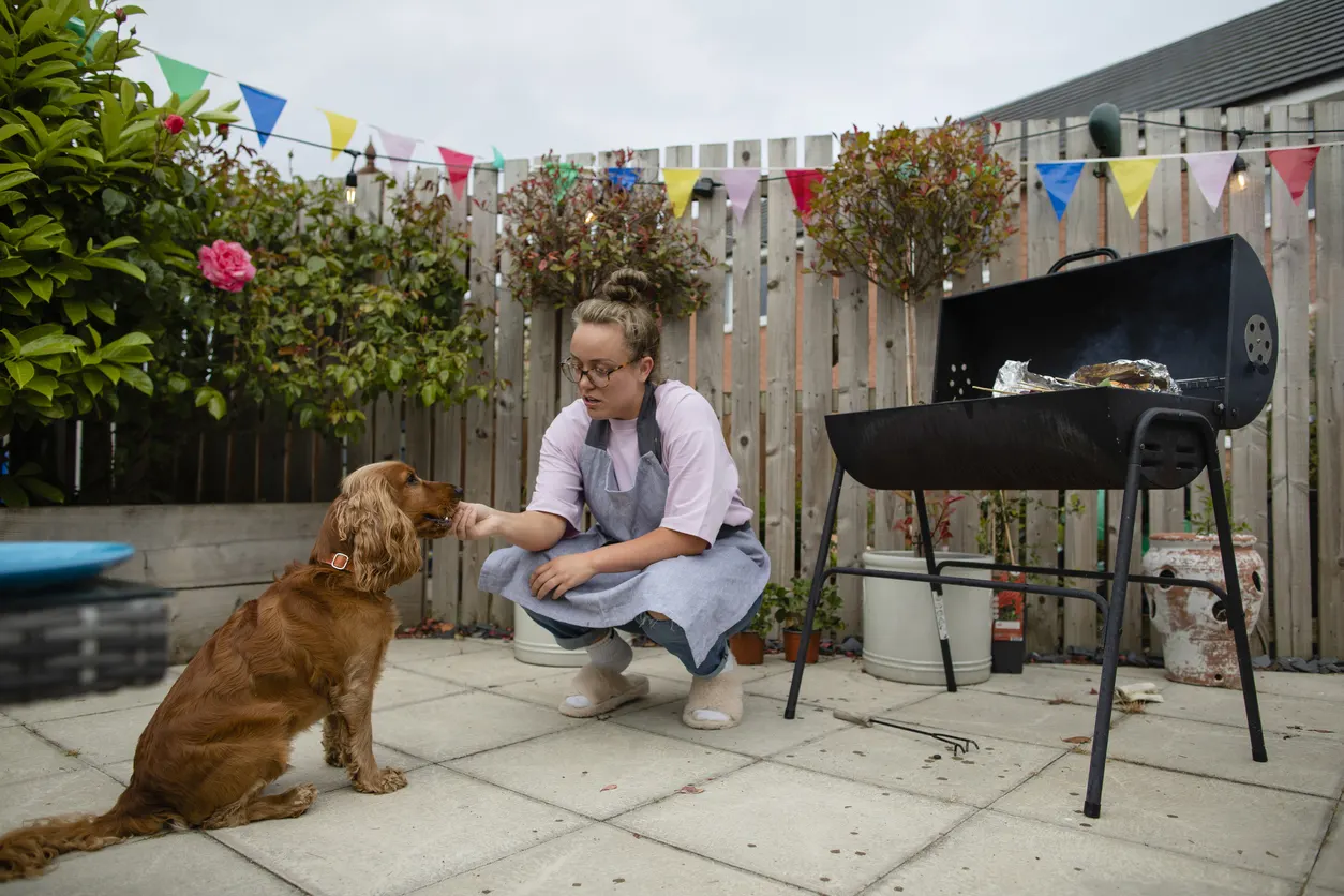 woman feeding dog treat outside