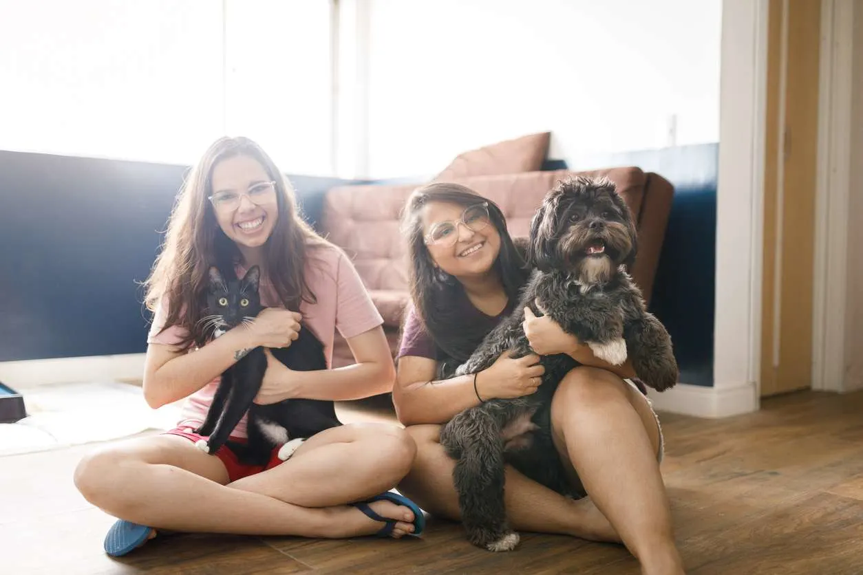 Two girls with dog and cat